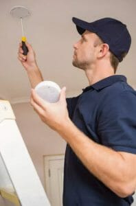 Handyman installing smoke detector man fixing smoke detector