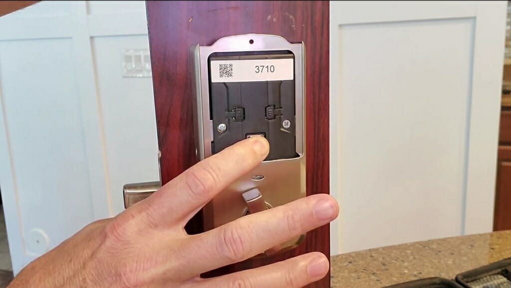 man pushing button on kwikset smartlock