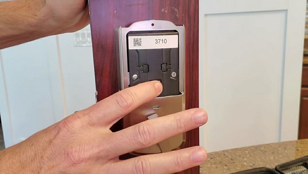 man's holding and pushing kwikset smartlock