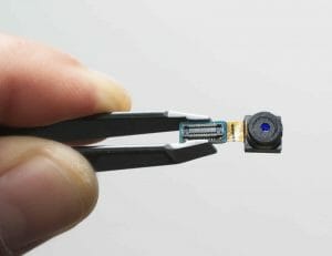 a hand holding a device and a mini camera