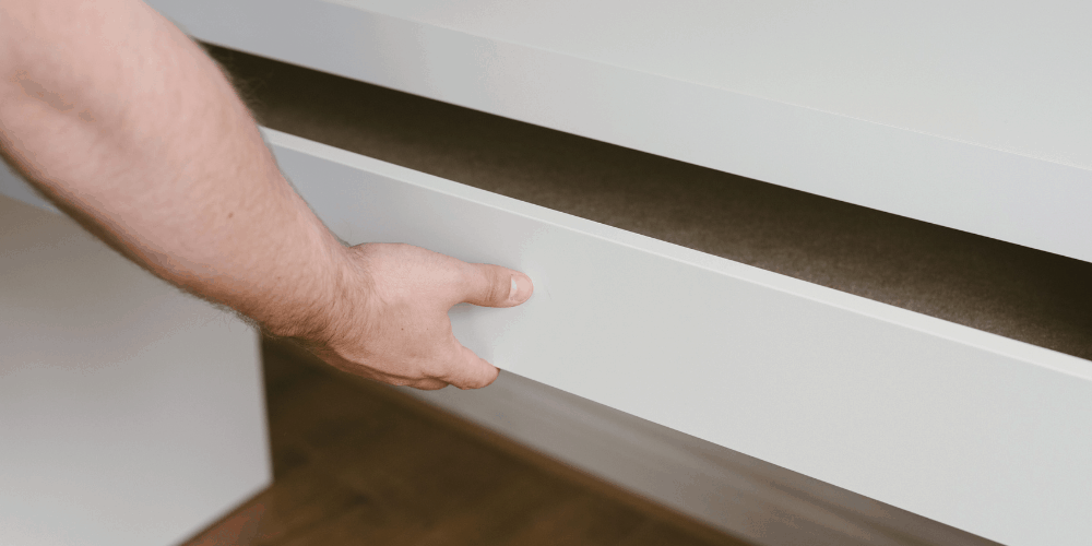 a man opening a table drawer