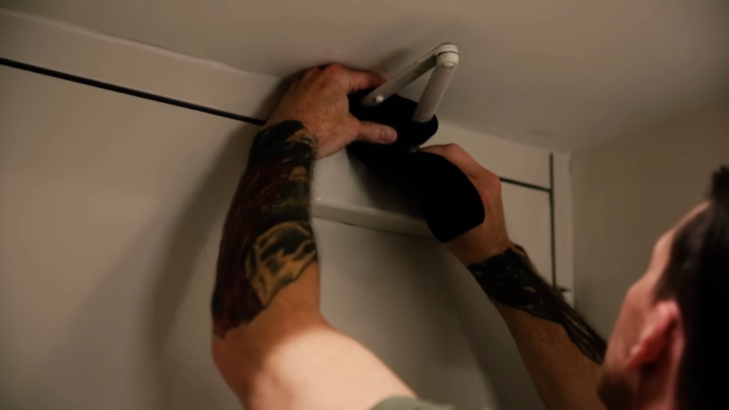 man putting belt on door