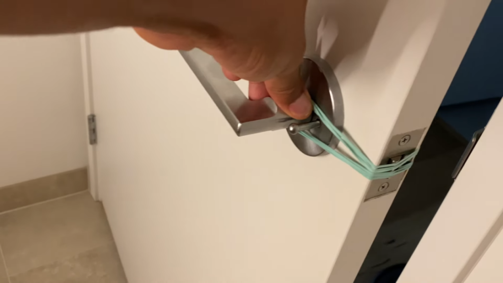 man holding doorknob with a rubber band